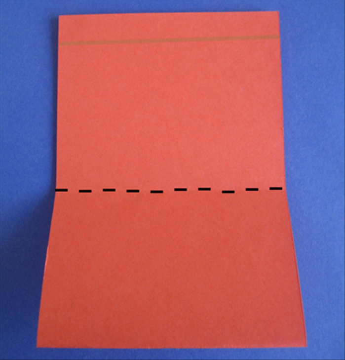 הניחו את הנייר כך שהחלק הפתוח מלמעלה.
קפלו את החלק התחתון כלפי מעלה עד כ1 ס'מ מתחת לקצה העליון.

