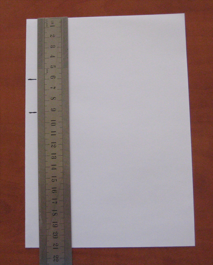 לאורך הדופן המקופל של הנייר, סמנו 2 קוים, האחד בגובה 6 ס'מ והשני בגובה 9 ס'מ