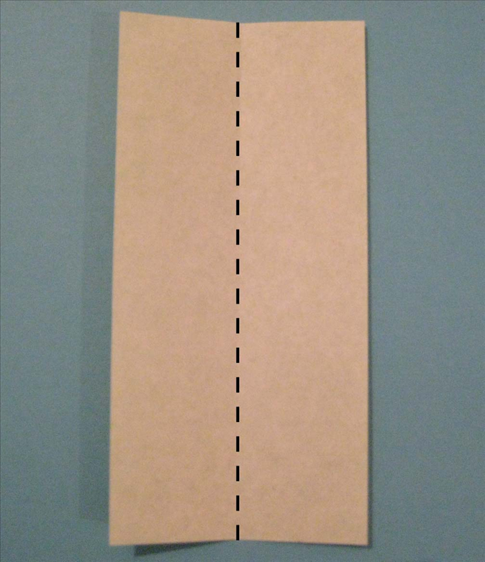 כאשר הנייר מונח על חלקו הצבעוני, קפלו את הנייר לחצי (לאורכו) ופתחו אותו שוב.